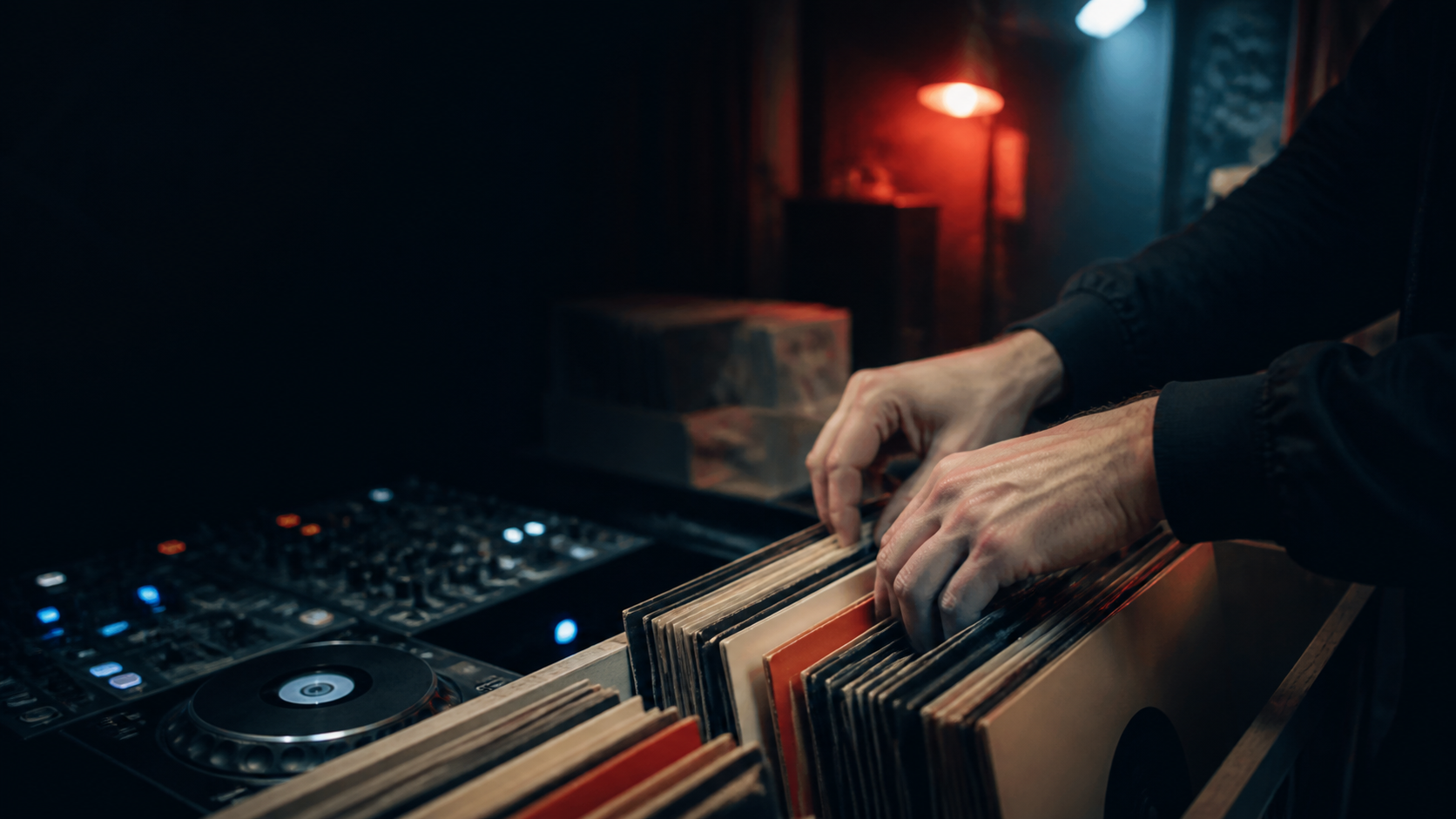 DJ selecting vinyl records while discovering new underground electronic music for DJs